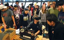 Crowd of students watching one person in front of a laptop with a VR headset on